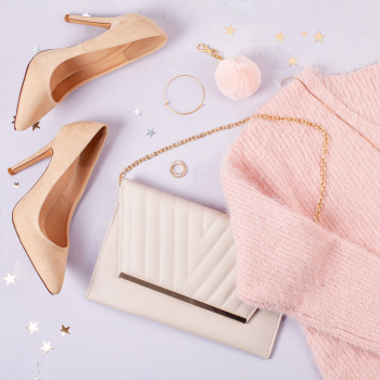 Flat lay of woman clothing and accessories in pastel colors