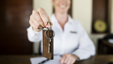 Receptionist handing room key to guest